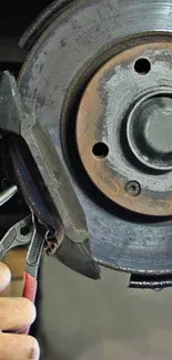 Mechanic adjusting a car brake disc with tools.