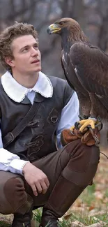 Medieval falconer kneels with a brown eagle in a natural setting.