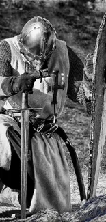 Armored medieval knight kneeling with shield and sword.