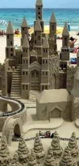 Detailed sandcastle on a sunny beach with sea in the background.