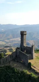 Medieval stone tower with mountain backdrop.