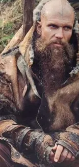 Bearded medieval warrior in rustic attire sitting outdoors.