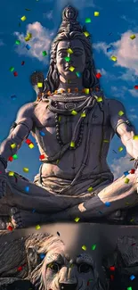 Majestic Shiva statue with vibrant confetti under a blue sky.