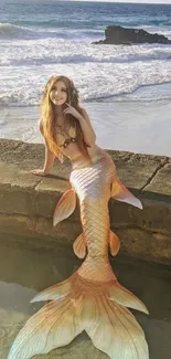 A beautiful mermaid sitting on a beach with ocean waves in the background.