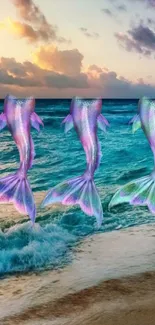 Three mermaid tails over a sunset-lit ocean waves on a beach.