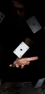 A hand tossing playing cards in a dark setting for a mysterious look.
