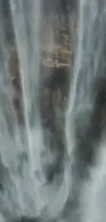 Waterfall cascading down gray rocks with mist.