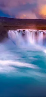 Vibrant waterfall with turquoise water under a colorful sky.