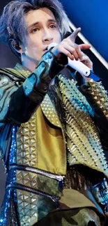 Performer in studded green jacket on stage.