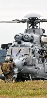 Military helicopter with soldiers in a grassy field.