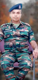 Military officer in uniform with camo in seated pose.