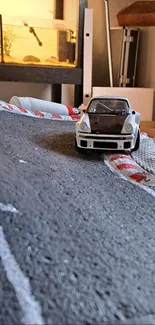 Miniature rally car on winding model track.