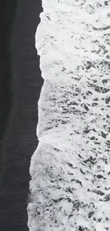 Aerial view of waves on a black sand beach wallpaper.