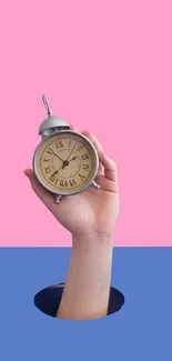 Hand holding a vintage clock against a pink and blue background.