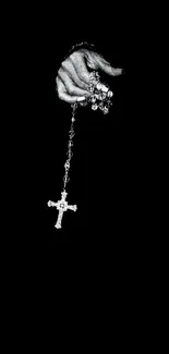 Hand holding cross on black background, minimalist design.