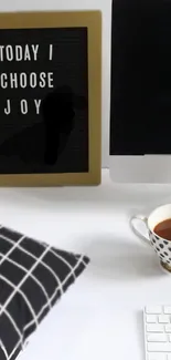 Minimalist desk with motivational art and coffee.