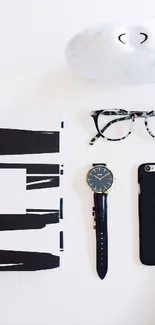 Minimalist flat lay with black and white essentials, including a watch and smartphone.