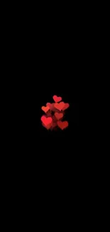 Minimalist wallpaper with red hearts on a black background.