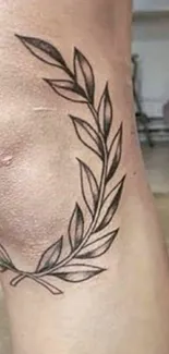 Minimalist tattoo of leaves on skin.