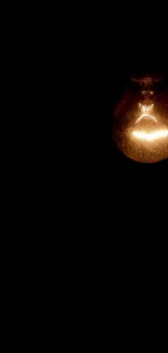 Glowing lightbulb on black background wallpaper.