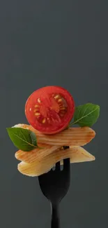 Fork with pasta, tomato, and basil against a dark background.