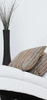 Minimalist wallpaper with vase and pillows.