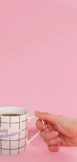 Minimalist pink wallpaper with coffee cup and hand.