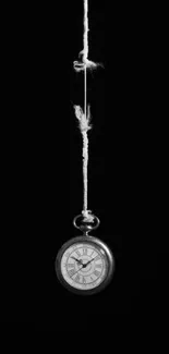 Minimalist black wallpaper with a hanging pocket watch.