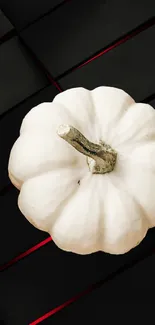 White pumpkin on dark geometric background with red accents.