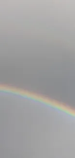 Minimalist wallpaper featuring a rainbow on a gray background.