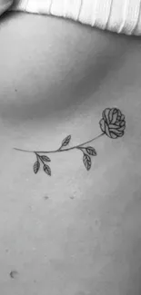 Minimalist rose tattoo line art on skin background.