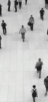 Monochrome city scene with people walking on a tiled surface.