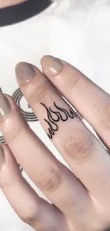 Minimalistic flame tattoo on finger with beige manicure