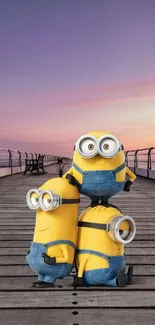 Three cheerful Minions on a dock at sunset.