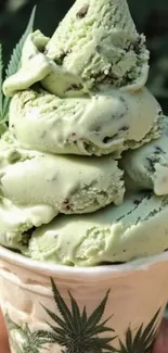 Mint green ice cream in a cone with a leaf decoration.