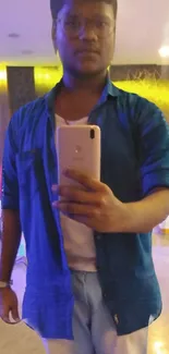 Mirror selfie in blue shirt with casual style.