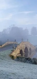 Stone bridge in a frosty, misty landscape with pale blue hues.