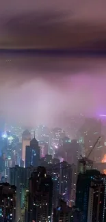 Misty cityscape with vibrant night lights under a foggy sky.