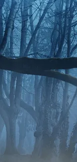 Misty blue forest wallpaper with trees and fog.