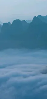 Misty blue mountains with clouds in a serene and tranquil setting.