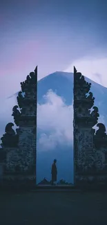 Misty mountain framed by ancient stone gates in tranquil landscape.