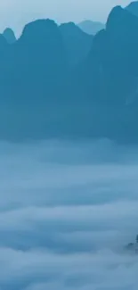 Misty mountain landscape with blue hues and serene foggy scenery.