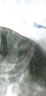 Misty mountain peak with green forest and cloudy sky background.