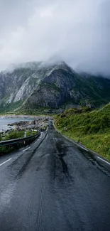 Misty mountain road with foggy peaks and lush green valley.