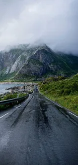 Misty road leading through mountainous landscape with foggy peaks.