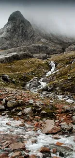 Misty mountain landscape with a stream and rocks.