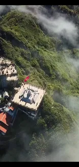 Aerial view of a temple on a misty green mountain.