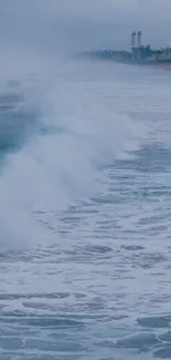 Misty ocean waves crashing on beach with serene sky.