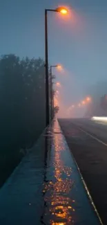 Misty night road with glowing streetlights creating a serene wallpaper scene.