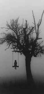 Misty silhouette of tree and swing wallpaper.